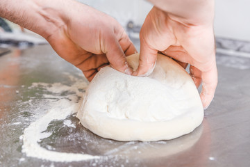 Cook forms a dough pizza base