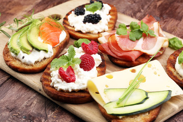 Bread Brushetta or authentic traditional spanish tapas set for lunch table. Sharing antipasti on party or summer picnic time over wooden rustic background.