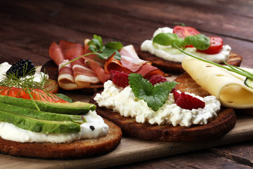 Bread Brushetta or authentic traditional spanish tapas set for lunch table. Sharing antipasti on party or summer picnic time over wooden rustic background.