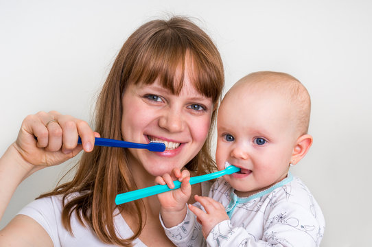 Mother and her baby brushing teeth together