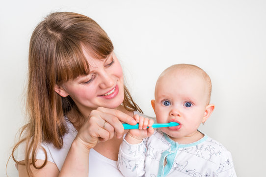 Mother and her baby brushing teeth together
