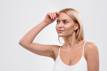 Flirty blond girl standing with pretty smile