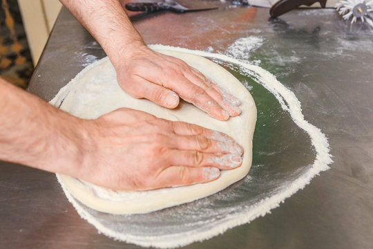 Cook forms a dough pizza base