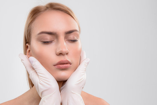 General practitioner analyzing human facial skin