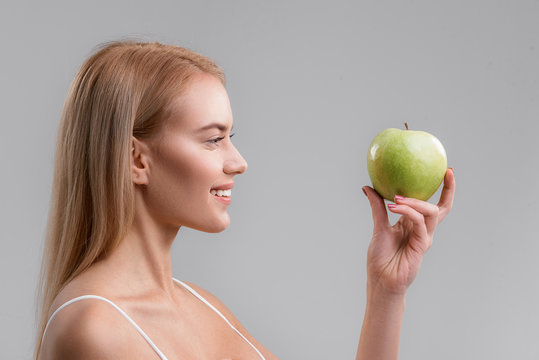 Pretty blond girl wants to eat an apple