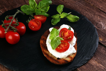 Bread with cream cheese and tomato for lunch table. Sharing antipasti on party or summer picnic...