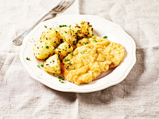 Breaded pork cutlet with baked potatoes; Polish cuisine