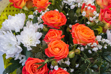 Bunch of big orange red tea roses and white chrysanthemum