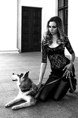 The girl with the siberian husky. Delightful girl plays with a Siberian Husky. Girl walking with a hunting dog - the West Siberian husky. Close-up. Fashion photo, black and white shot.