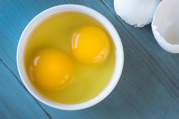 Egg yolks in a bowl on blue background