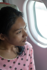 woman looks out the window of an airplane