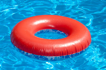 Inflatable red swim ring on blue pool
