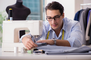 Young man tailor working on new clothing