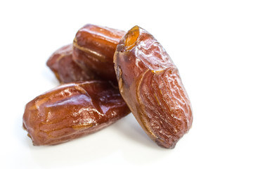 Dried dates fruit over a white background.