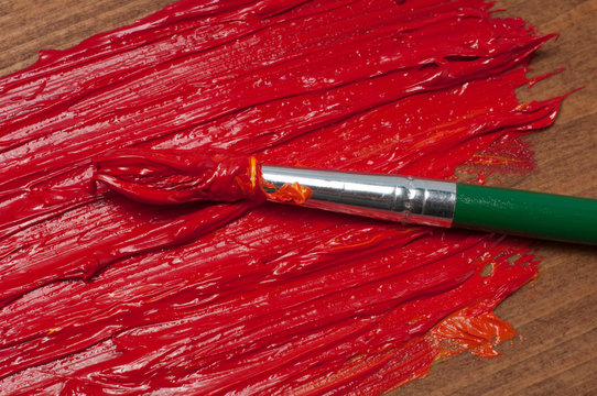 Red Oil Paint Tube And The Brush On The Wooden Background