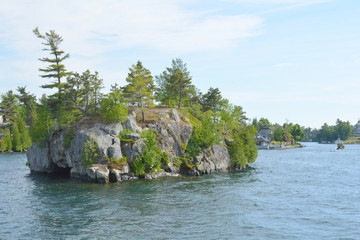 1000 Islands Region. Sunny summer day. Rocky Island on the St. Lawrence River crowned with pine...
