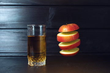 Glass of apple juice with sliced apple hanging in air