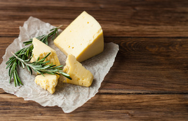 Hard cheese on a wooden table. Dairy products and agriculture.