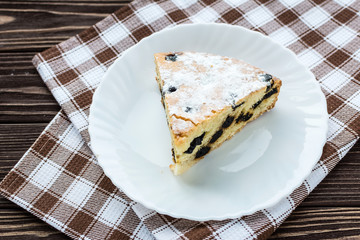 Сherry pie sprinkled powdered sugar on wooden background