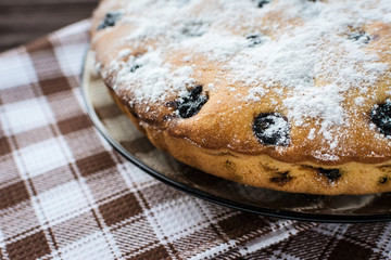Сherry pie sprinkled powdered sugar on wooden background