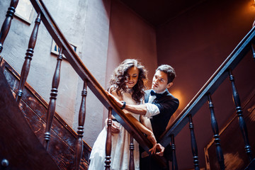 Fashionable young couple standing on stairs and hugging each other