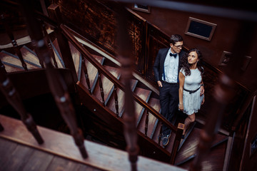 Fashionable young couple standing on stairs and hugging each other
