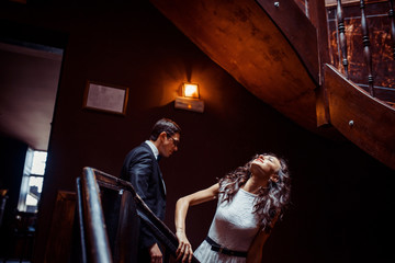 Fashionable young couple standing on stairs and hugging each other