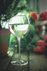 A glass of water on the flowers and plants against