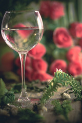 A glass of water on the flowers and plants against
