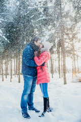 Fototapeta na wymiar Young couple having fun in the winter forest