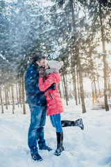 Fototapeta na wymiar Guy and girl walk ,have fun in the forest in winter