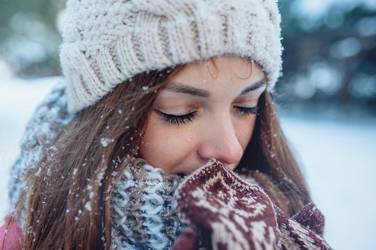 The Girl Warms Hands In Mittens In Winter Forest. Snow On Eyelashes