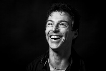Close up portrait of hard laughing  man. Isolated on black background . Monochrome picture
