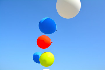 Unfiltered, with natural lighting, multicolor balloons on blue sky, happy birth day in summer and wedding honeymoon decoration.