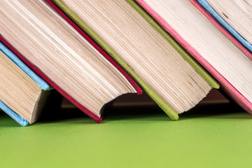 Old books on a wooden shelf. No labels, blank spine.