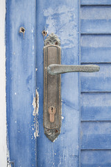 stare zużyte niebieskie drzwi z metalową klamką w Santorini Grecja - 138608137