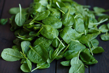 Fresh green spinach on the dark wood background