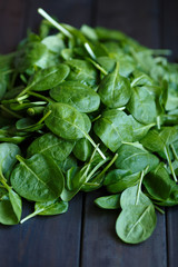 Fresh green spinach on the dark wood background