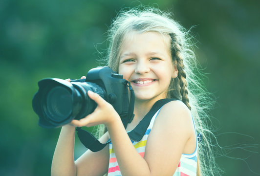 little girl with camera outdoors.