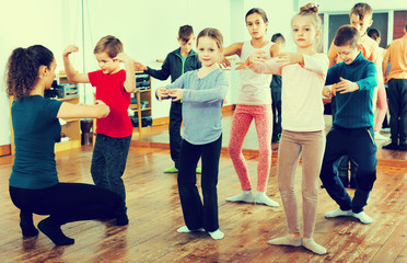 Young ballet dancers exercising in ballroom