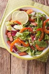 Tasty salad of shrimp, chorizo sausage and mix lettuce close-up. vertical top view