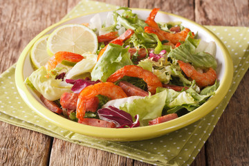 Homemade salad of shrimp, chorizo sausage, lime, and mixed greens close-up. horizontal