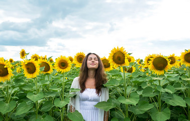 beautiful girl standing relaxed in sunflower field