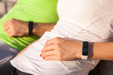 Obraz premium Two people using smart sport watch at workout.