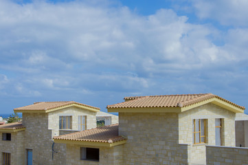 Fototapeta na wymiar Construction of the stone house on a background of blue sky, Hersonissos Greece