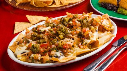 Mexican food: nachos with melted cheese, tomato and peppers.