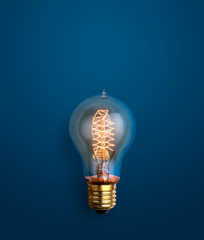 light bulb glowing on blue background creative ideas background concept.