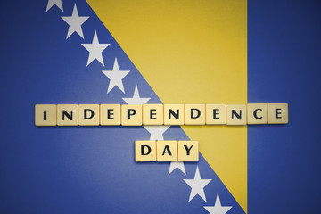 letters with text independence day on the national flag of bosnia and herzegovina.