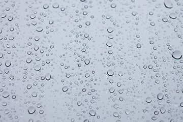 Water drops on glass white abstract background