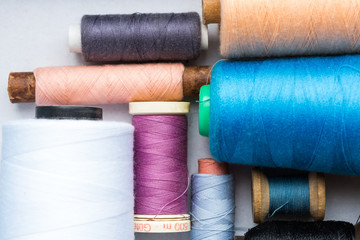 different sizes of the color bobbin of thread lying on a white background. the concept from color threads. sewing background. top view. flat lay.